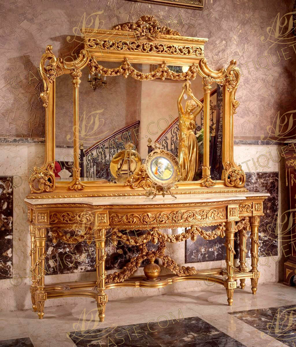 Monumental and Palatial Italian 19th century Louis XVI style carved and gilt wood grand console with mirror hand carved garlands, swags, blossoms and pierced carvings all over, the beautiful piece is gilded with French gold leaves and raised on tapered reeded legs coiled with descending floral garlands above toupie shaped acanthus leaves carved feet and rosette block, The legs are joined by a double rounded geometric beaded stretcher centered with an urn of prosperity and acorn finial above flanked by leaf garlands and blossoming flowers. The serpentine shape base is marble topped and of opulent apron bas-relief panel intricately carved with foliage and a flower amongst acanthus leaf scrolls above swagged floral garland central reserve with floral leaf carving below. The mirror has an elaborately carved floral acanthus and vines border with two fluted foliate crowned columns flanking central swagged floral garland surmounted with acanthus scrolls pierced relief. The curved top with impressive top tied ribbon crown surmounted with blossoming flowers